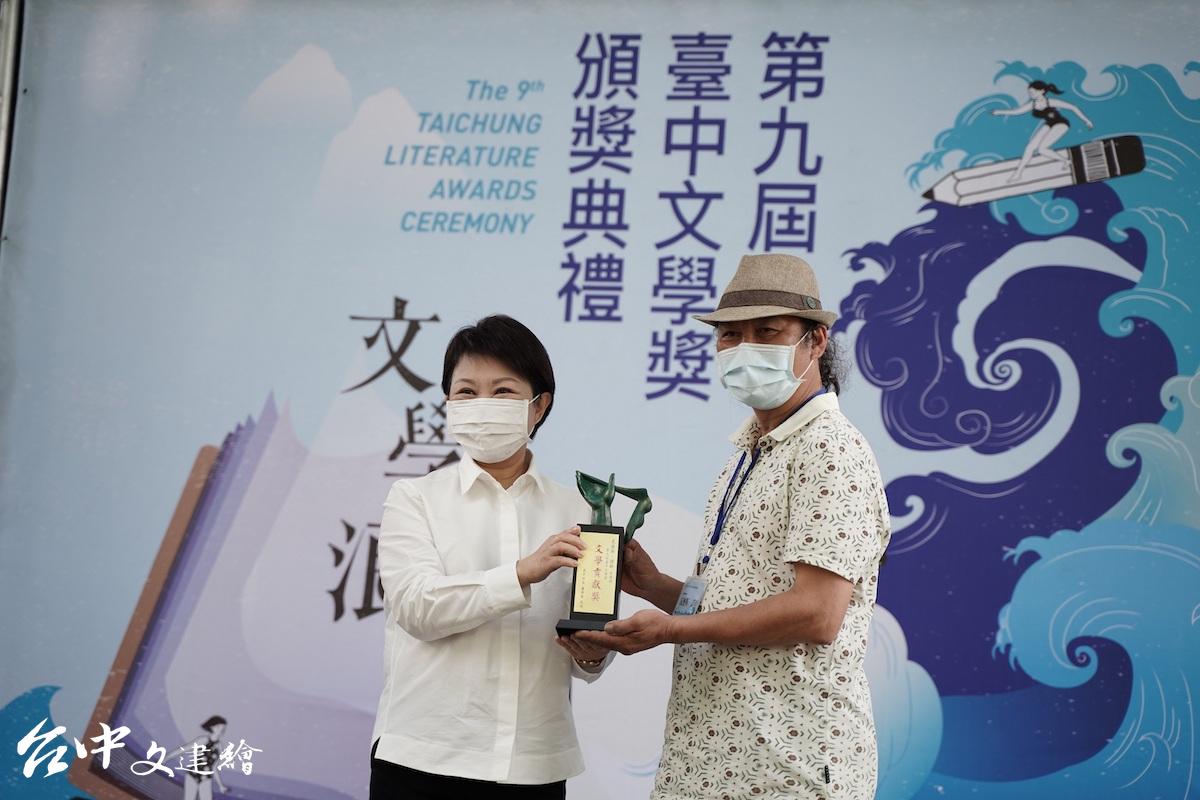 第九屆台中文學獎,市長盧秀燕(左)頒獎給文學貢獻獎得主瓦歷斯・諾幹(右)。(圖:台中市文化局)
